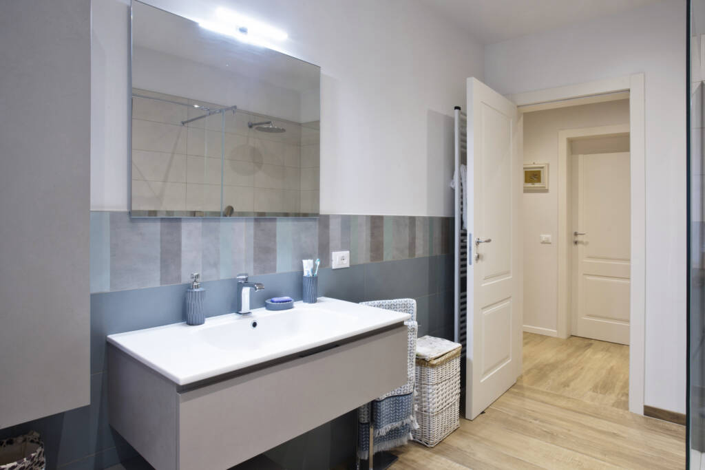 Foto di un bagno bianco e grigio con specchio